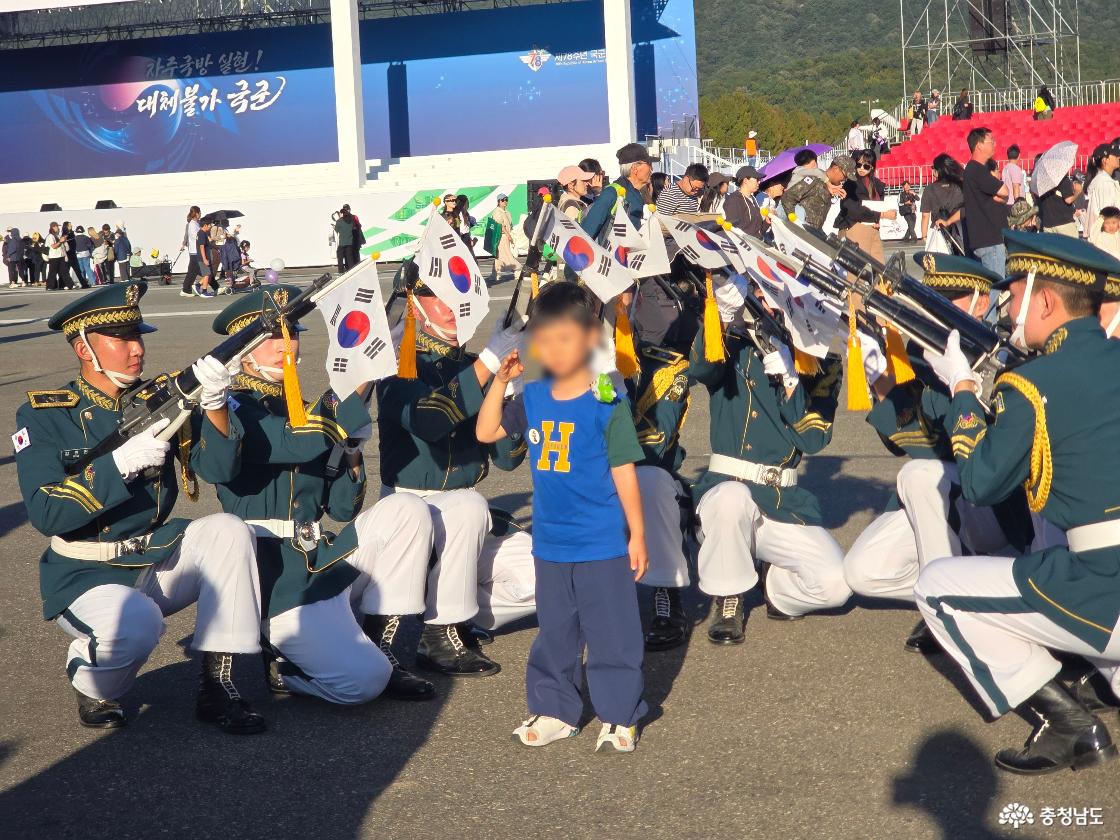 1. 계룡군문화축제 현장에서 군악대원들과 함께 기념사진을 촬영하는 어린이