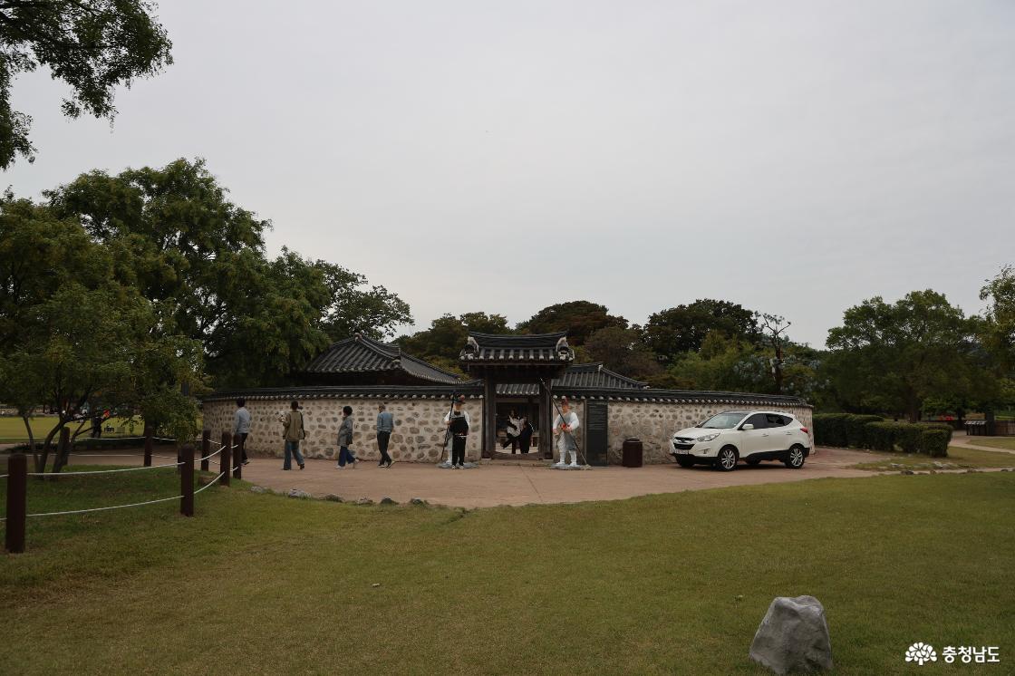 해미읍성 안 돌담과 기와지붕으로 둘러싸인 옥사 입구를 둘러보는 방문객들