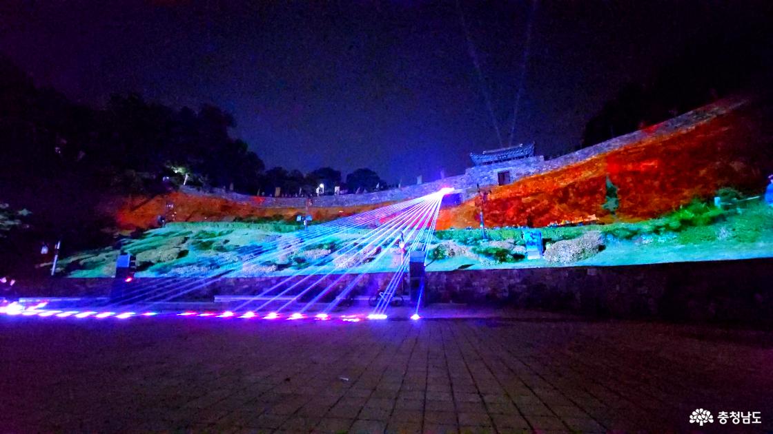 공주 공산성의 경사면을 주황색과 초록색으로 밝히고 푸른 레이저를 펼치는 미디어아트