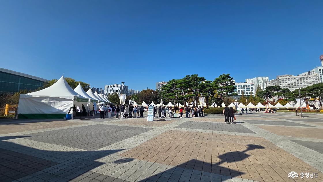 맑은 하늘 아래 열린 2026 빵빵데이 천안 행사장. 광장을 둘러싼 흰색 천막 부스와 줄을 선 방문객들.