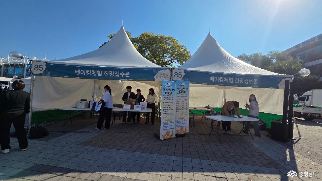 2026 빵빵데이 천안 85번 베이킹체험 현장접수존. 접수대에서 신청서를 작성하는 방문객과 안내하는 운영진.