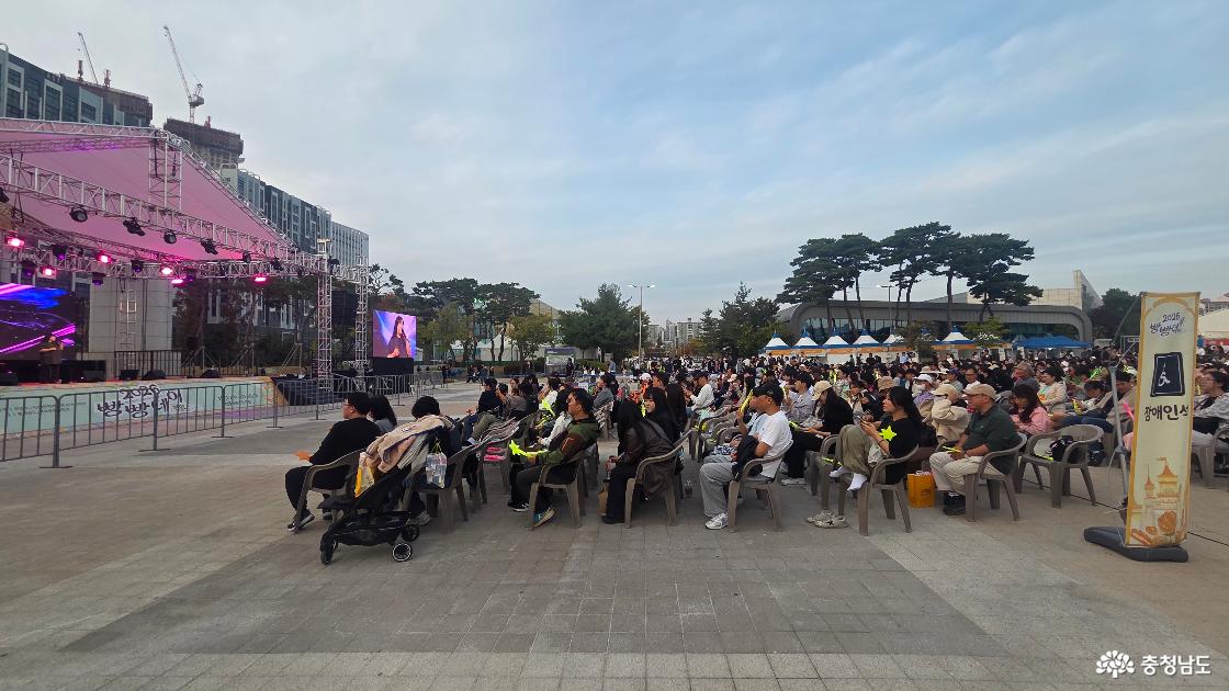 빵빵데이 주무대 앞 관람석을 채운 방문객들. 공연을 보며 응원 도구를 든 관객들과 객석 옆 장애인석 안내 표지.