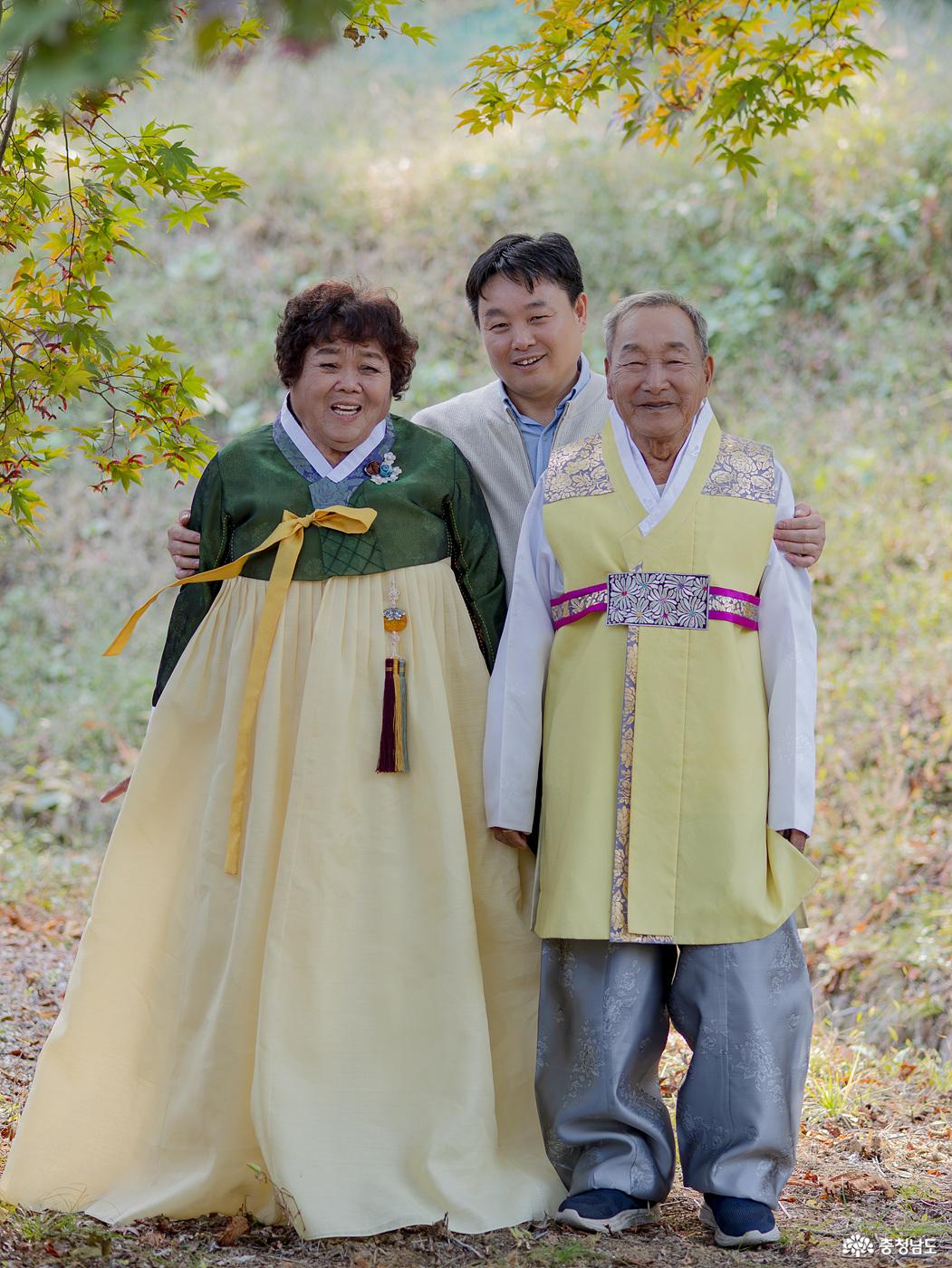 이문호(1940년생)·김용숙 부부가 자녀들과 함께 진충사의 나무 그늘 아래서 가족사진을 찍고 있다. 이날 행복사진 촬영에는 자녀들도 동행해 부모님과 특별한 추억을 남겼다.